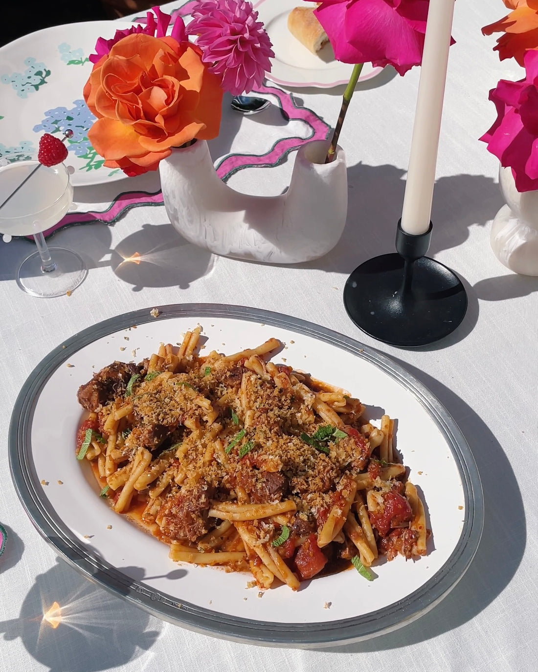 The image on the left is a plate of lamb ragu on an outdoor table setting, on the right are the ingredients used. @intothesauce, Into the Sauce, Tori Falzon, #intothesauce