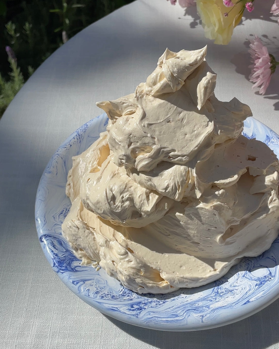 A tower of whipped butter on a set, outdoor table. On the right are the ingredients to make the butter. @intothesauce, Into the Sauce, Tori Falzon, #intothesauce